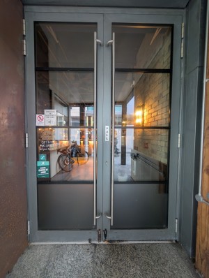 Grey frame doors. Metal handles in center. Pull to open. Small bump at entrance.