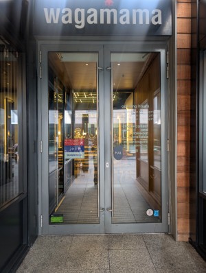 Grey frame doors. Metal handle from top to bottom in center. Pull to open.