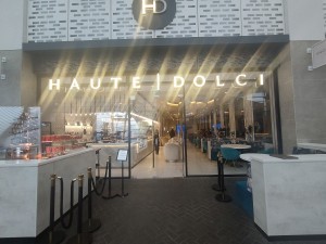 Facing venue entrance, dessert display counter to left, seating to right. Clear centre path.