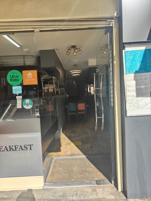 Glass door ahead, push the silver handle on left to open.