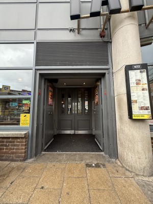 From street facing straight. Grey doors. Push in centre to open. Followed by preceding grey doors.