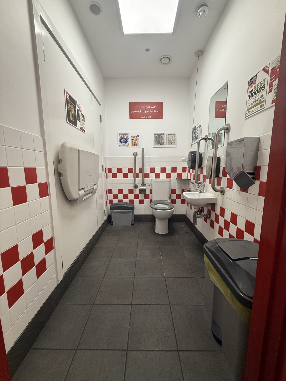 From toilet door facing straight. Baby change on left. Toilet on back right. Emergency cord on right. Sink on right.
