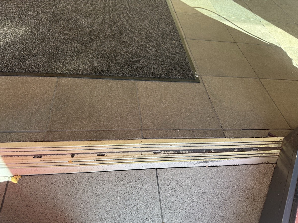 Metal bump at entrance followed by doormat.