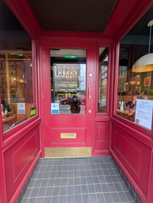 Red frame door. Gold metal handle on top. Pull to open.
