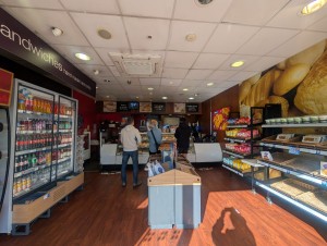 From entrance facing straight. Refrigerator and food display along both sides. Display in center. Counter along back wall.