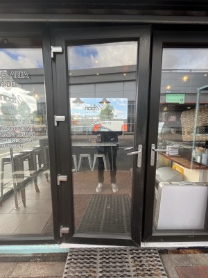 Glass door with a black frame. Handle on right. Pull to open.