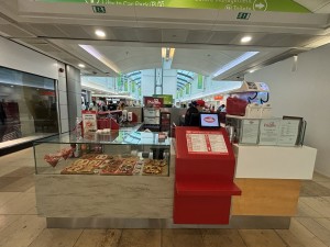 Display counter and counter in centre of pathway in mall.