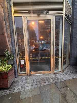 Glass door with wooden frame ahead. Pull metal handle at right of door to open.