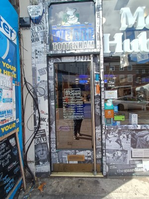 Glass door with silver handle on right. Push to open.