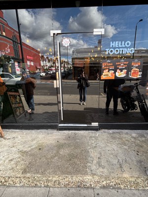 Glass door with metal handle on left. Push to open.