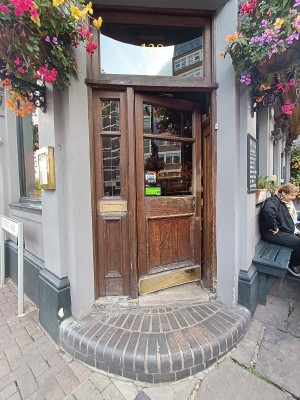 Glass door with brown, wooden frame ahead. Push from right to open.