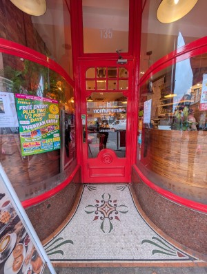 Red frame door in front. Bronze metal handle on left. Pull to open.