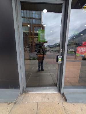 Grey frame door in front. Metal handle on right. Push to open.