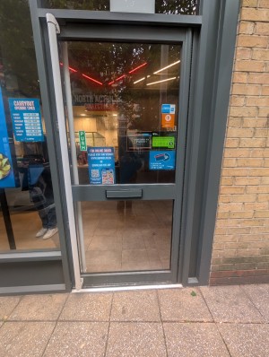 Grey frame doors. White handle along left. Push to open.