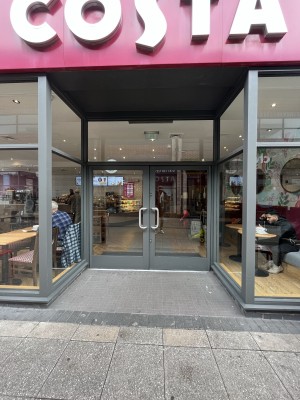 Archway to door with glass walls and a grey frame.