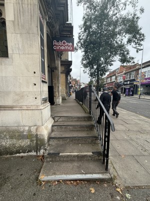 From left end of venue, facing right. Stairs ahead. Black, metal handrails along right.