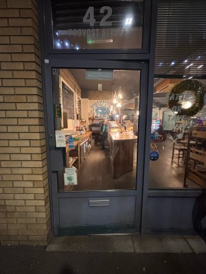 Glass paneled door with grey frame ahead. Pull grey metal handle at left to open.