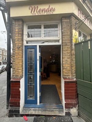 Glass door with blue, wooden frame ahead. Push from right to open.