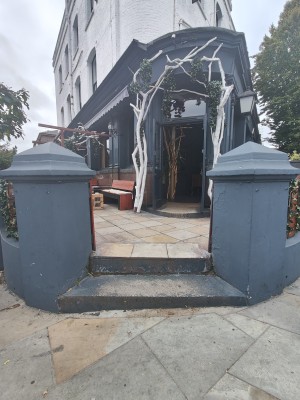 Two steps up to preceding half wooden doors. Push from centre to open.