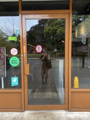 Orange framed glass door with metal handle on left side of door. Pull the handle from left to open.