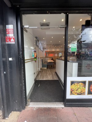Glass door with metal handle on right. Push to open.