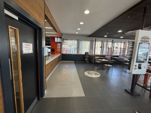 From entrance facing straight. Door to toilet on left. Counter behind. Seating on right.