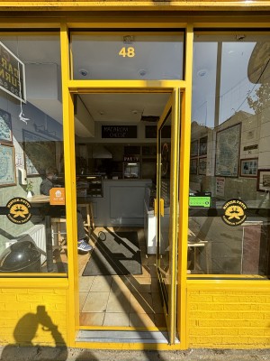 Yellow framed glass door ahead. Push door inwards to enter.