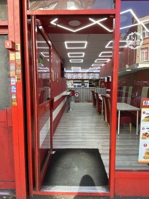 Red framed glass door. Push from right side of door to open.