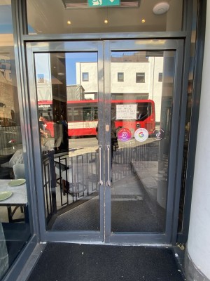 Grey framed glass door. Silver metal handle in centre. Pull to open.