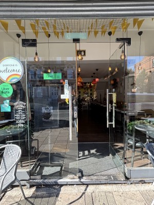 Double glass doors with metal handles in centre. Push to open. Glass walls on either sides, stickers on left side