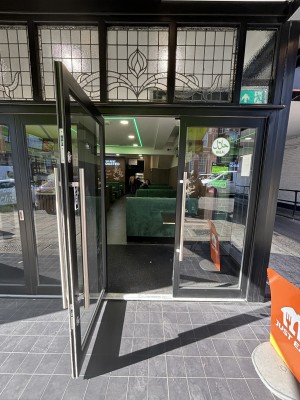 Black framed glass doors ahead. Pull silver handles to open door outwards.