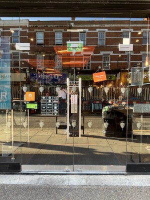 Double glass doors with metal handles in the centre, push to open. Glass walls on either side