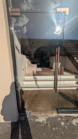 Glass door. Push handle on the right to open.