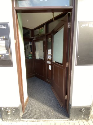 Brown door with glass panel. Push from left to open.