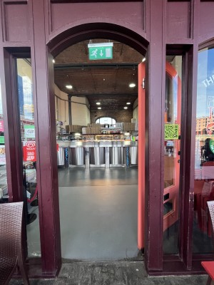 Glass door with pink frame and handle on left. Push to open.