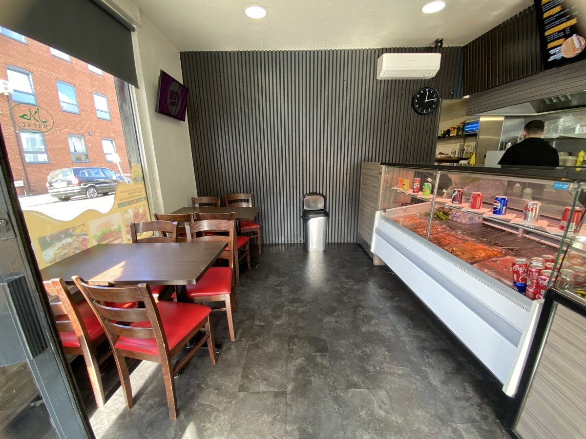 From entrance facing left. Tables and chairs along left. Display counter right.