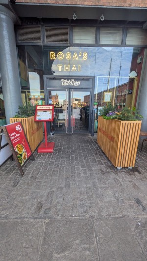 From street facing venue. Wooden planters on both sides. Menu boards on left