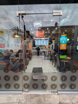 Glass door in front. Silver metal handle on left. Push to open.