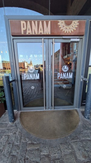 Glass doors with grey frame. Pull handles in center to open.