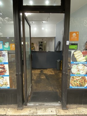 Black framed glass door. Black metal handle on right side of door. Push from right to open.