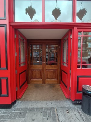 Glass doors with red, wooden frame. Push from middle to open.
