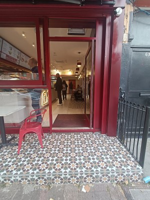 From street, facing venue. Step up ahead to outdoor seating on left. Doorway at back.