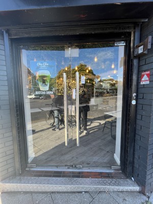 Glass double door with black frame and handle in centre. Push to open.