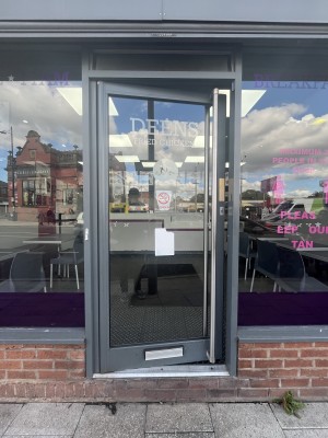 Glass door with a grey frame. Handle on right. Push to open.