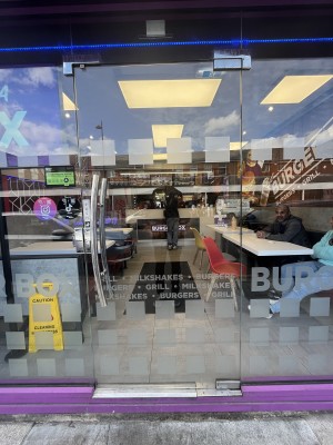 Glass door with handle on left. Push to open.