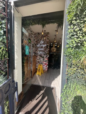 Glass door with grey frame. Handle on right. Push to open.
