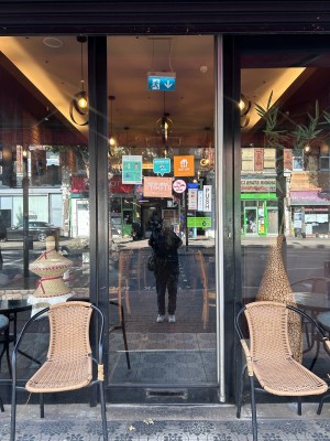 From sidewalk facing venue. Glass door with black frame. Push from right to open.