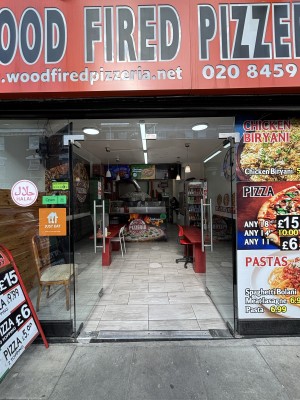Glass double doors with metal door handles in the centre. Glass walls along the front of the venue, advertising on the right wall