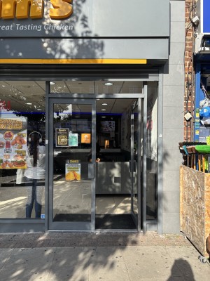 Glass double doors with dark gray frame, door handles at the centre. Glass wall to the left