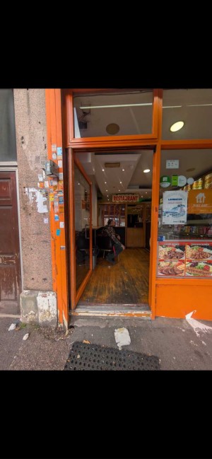 Glass door with orange metal frame ahead. Push from right to open.